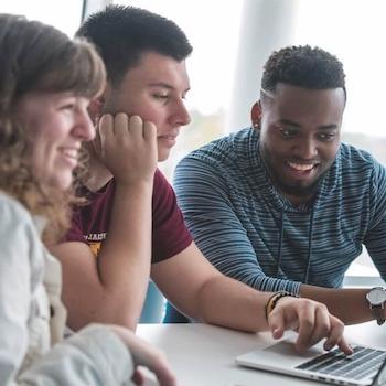 three students collaborating at a table